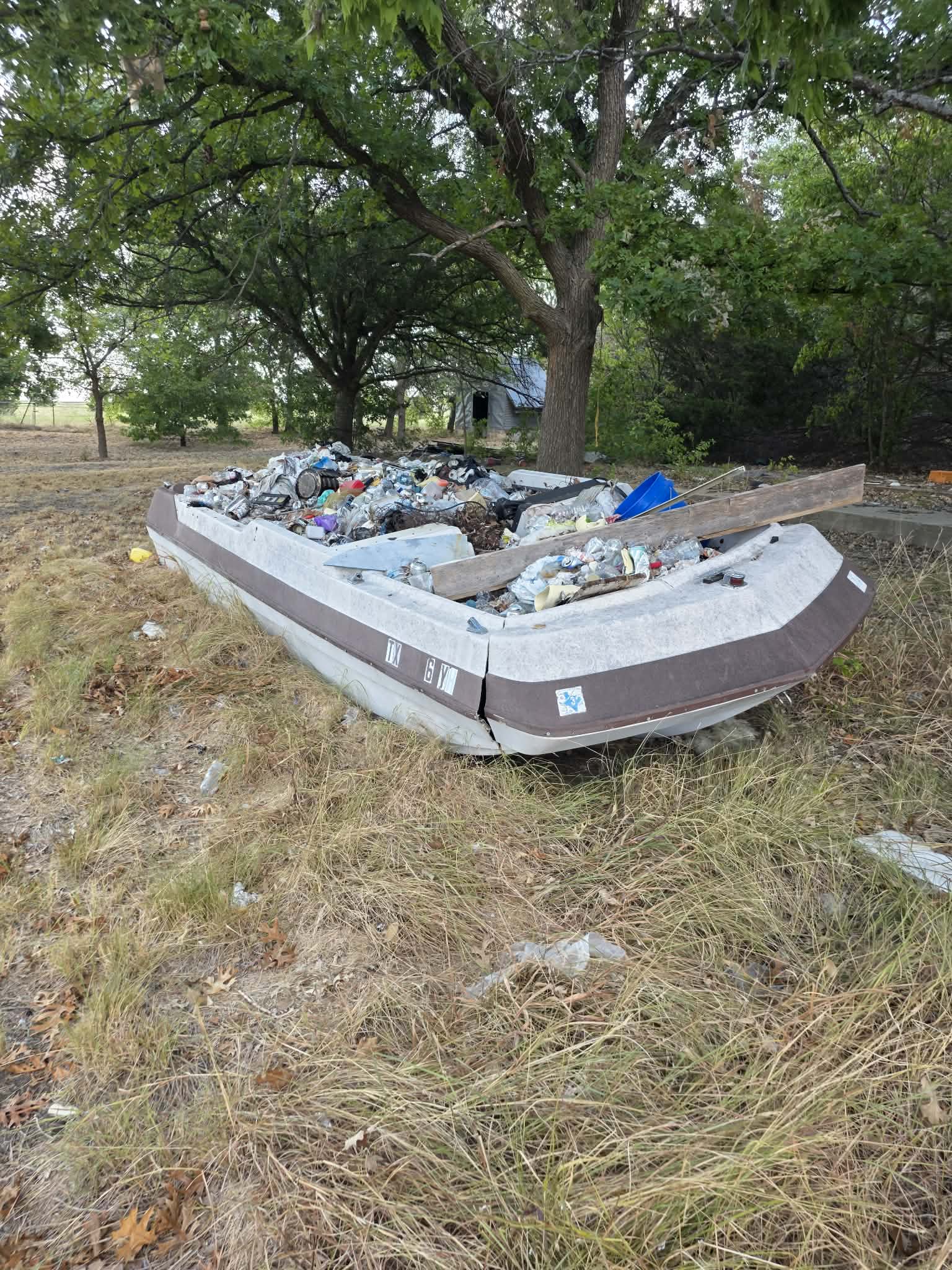 Damaged boat hull filled with unwanted debris before removal